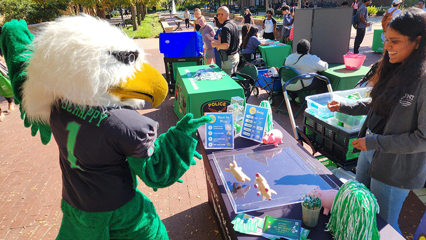 Scrappy Eagle Mascot is talking to student about the Eagle Outreach program