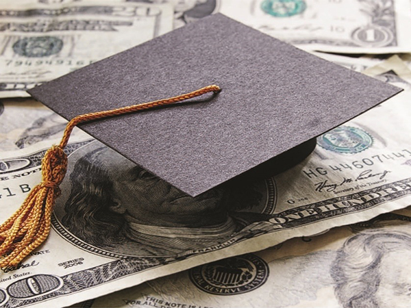 Graduation cap on top of hundred dollar bills